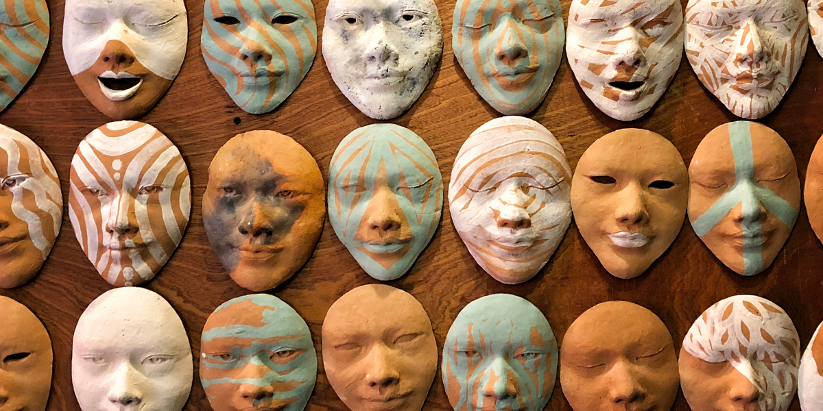 masks on a table with different faces and emotions