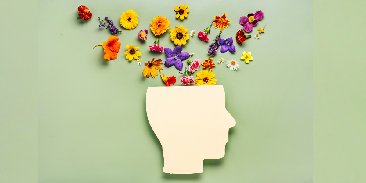 Image of a paper head cutout with flowers coming out to signify mental load